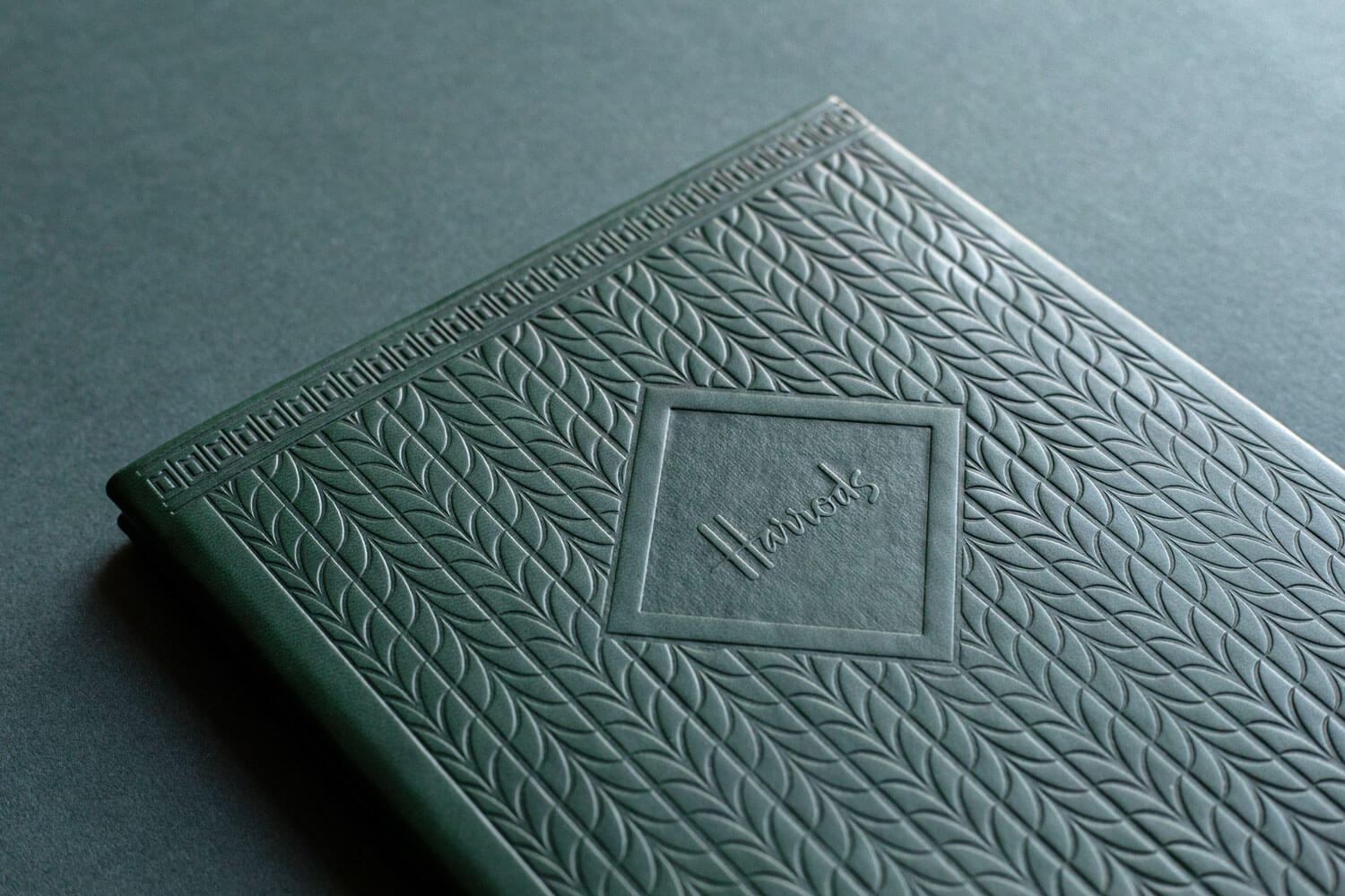 premium green leather menu holder with embossed pattern and harrods logo
