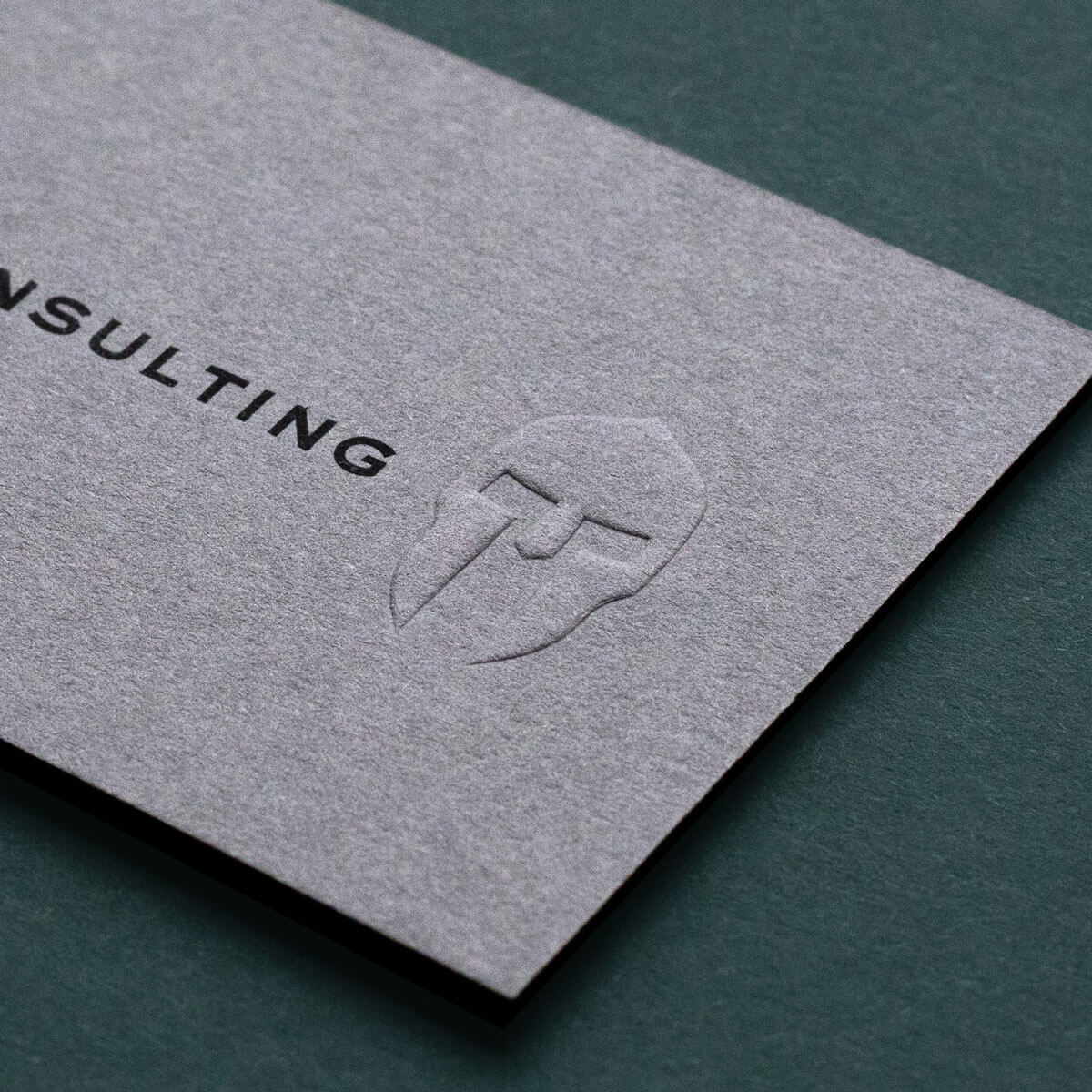 a grey business card with embossed logo
