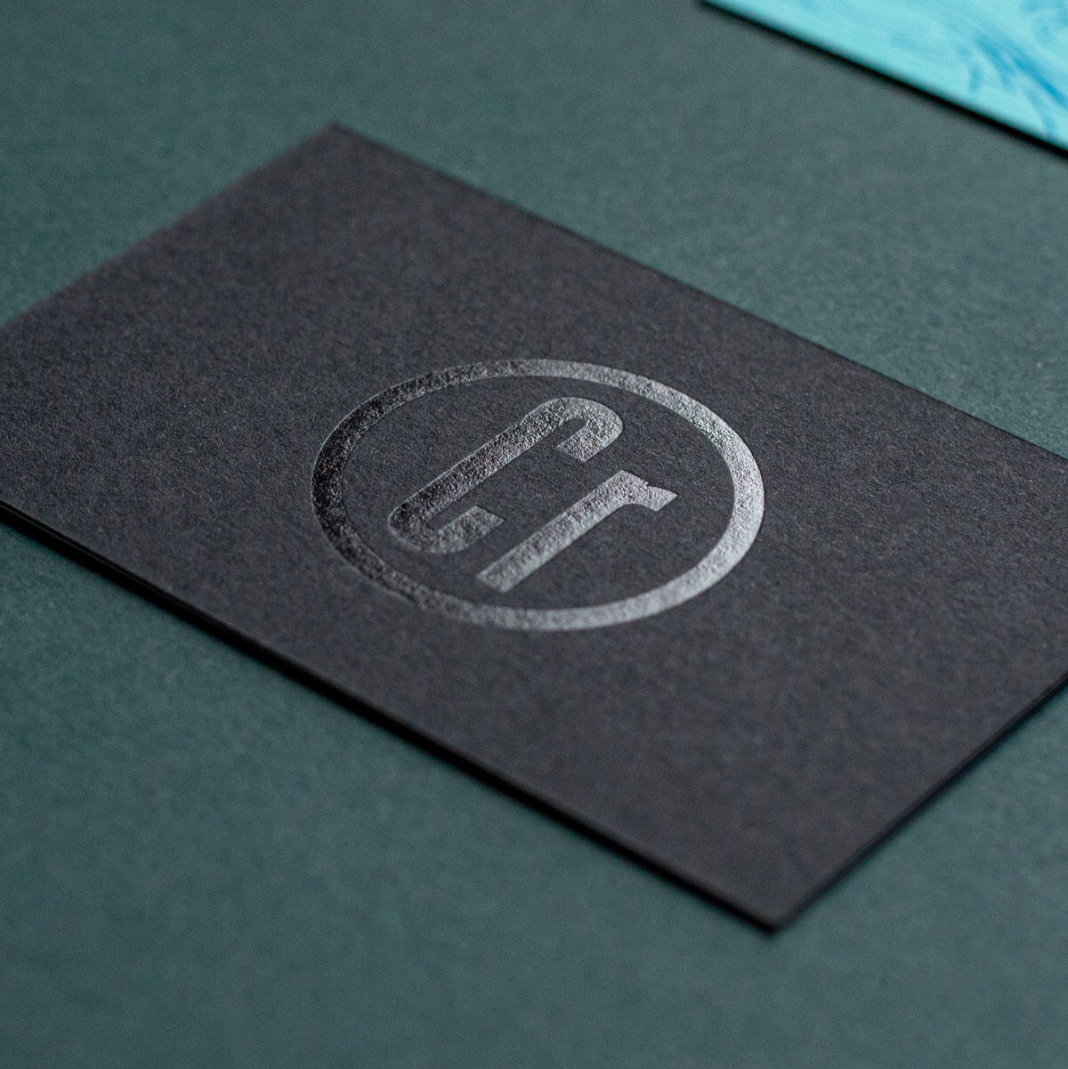 a premium textured black business card with a corporate logo foiled in black with the letters Cr