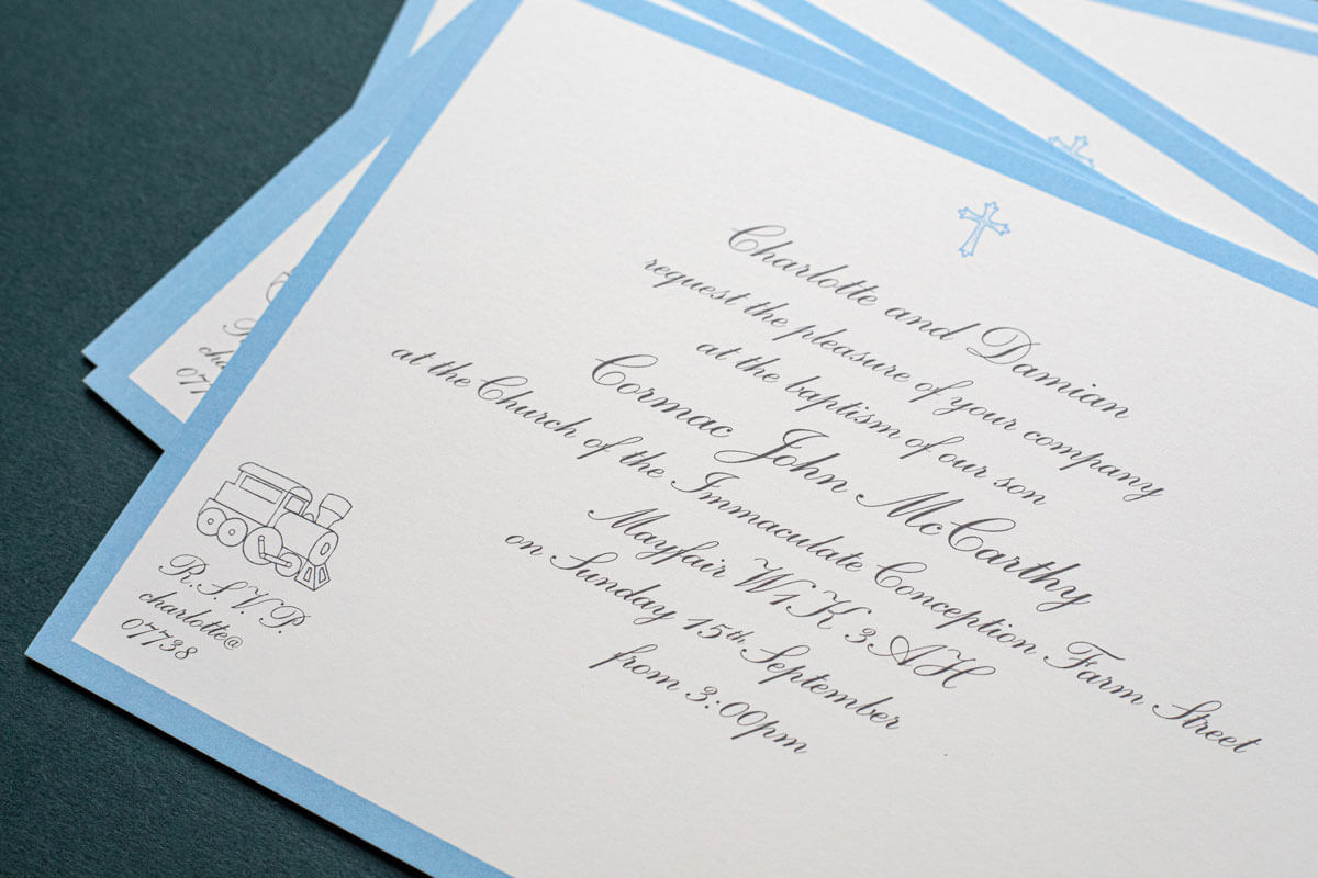 a premium bespoke high quality white christening invitation with a baby blue border and black calligraphic text