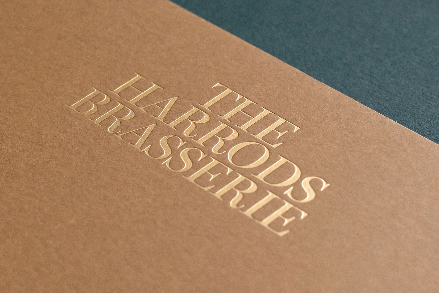 a high end gold foiled logo printed on a restaurant menu saying the harrods brasserie