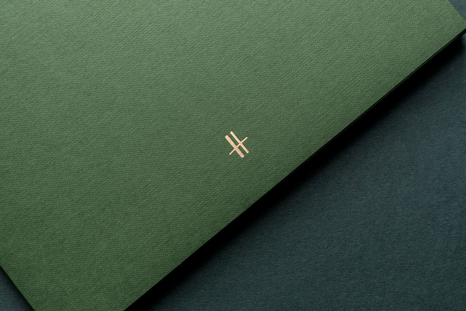 a luxurious green textured paper brochure with the iconic Harrods gold foiled