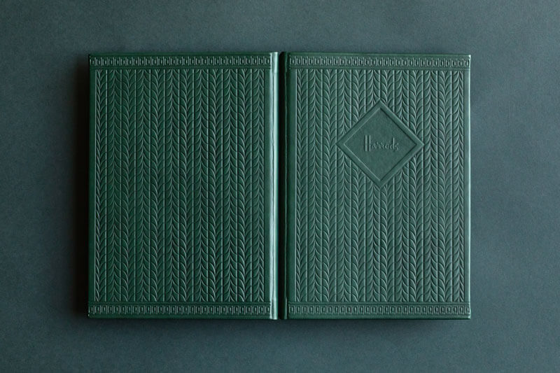 premium green embossed leather menu holder with front and back pattern and harrods logo
