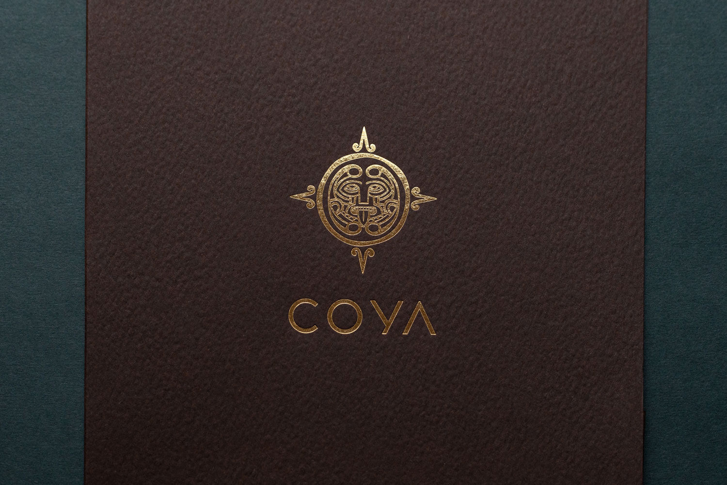 a gold foiled mayfair restaurant logo printed on a luxurious textured card saying COYA